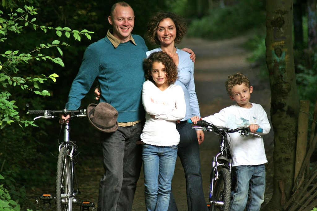 Family in the park with bikes. A brother and sister with their parents