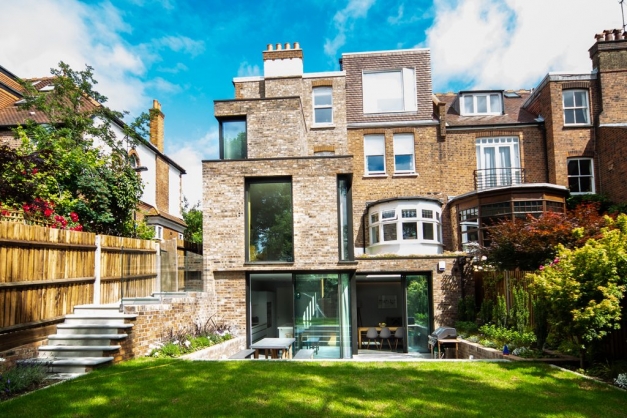 View of back of large house from the end of the garden with sliding glass doors going into the kitchen