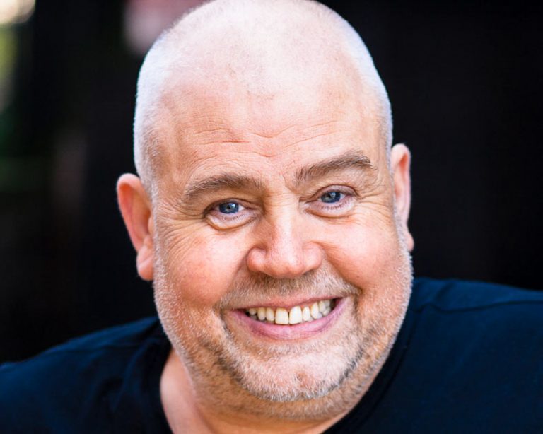 Man with blue eyes smiling into camera