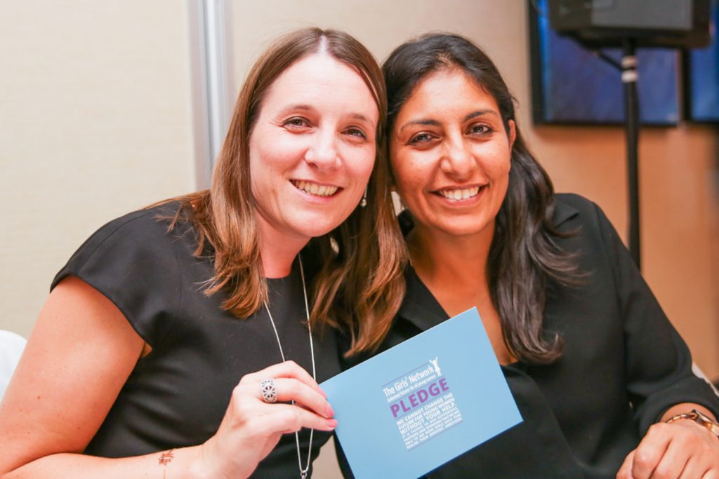 Two women smiling at a charity event