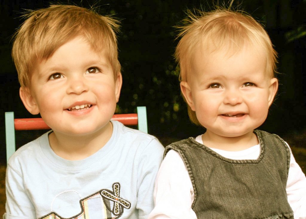 Brother and sister sitting on chairs laughing and looking upwards
