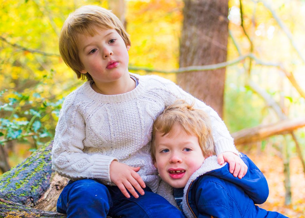 Two brothers hugging in the woods