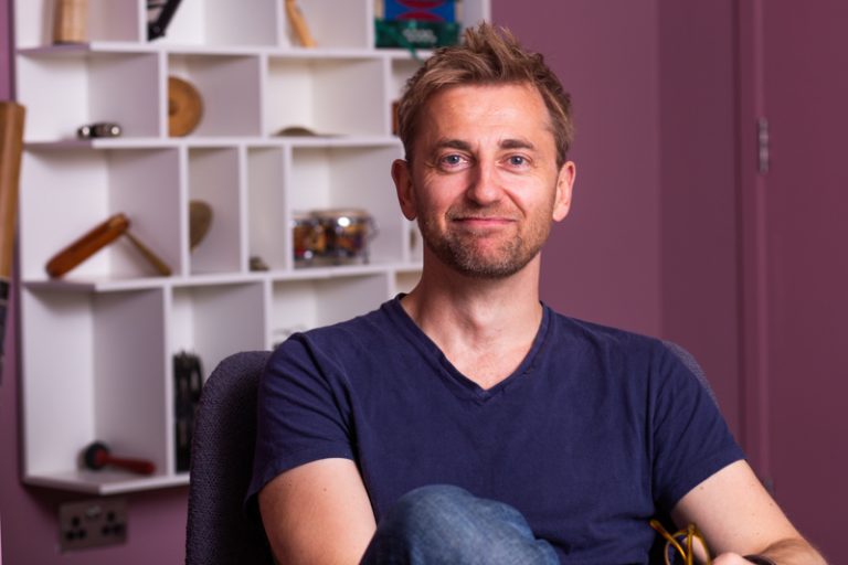 Casual picture of man in tshirt and jeans sitting on chair