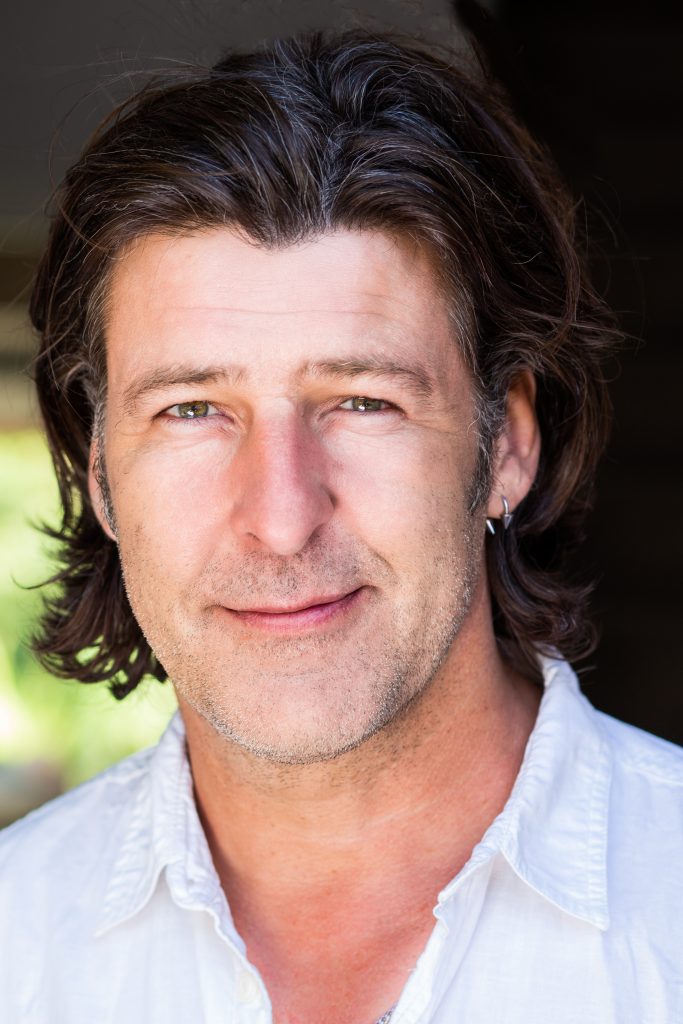 Cheerful man with dark long hair and an earring