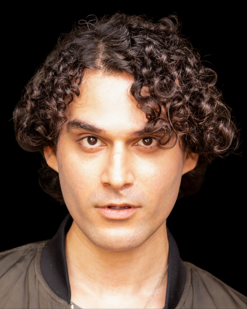 Actor with curly black hair and dark brown eyes