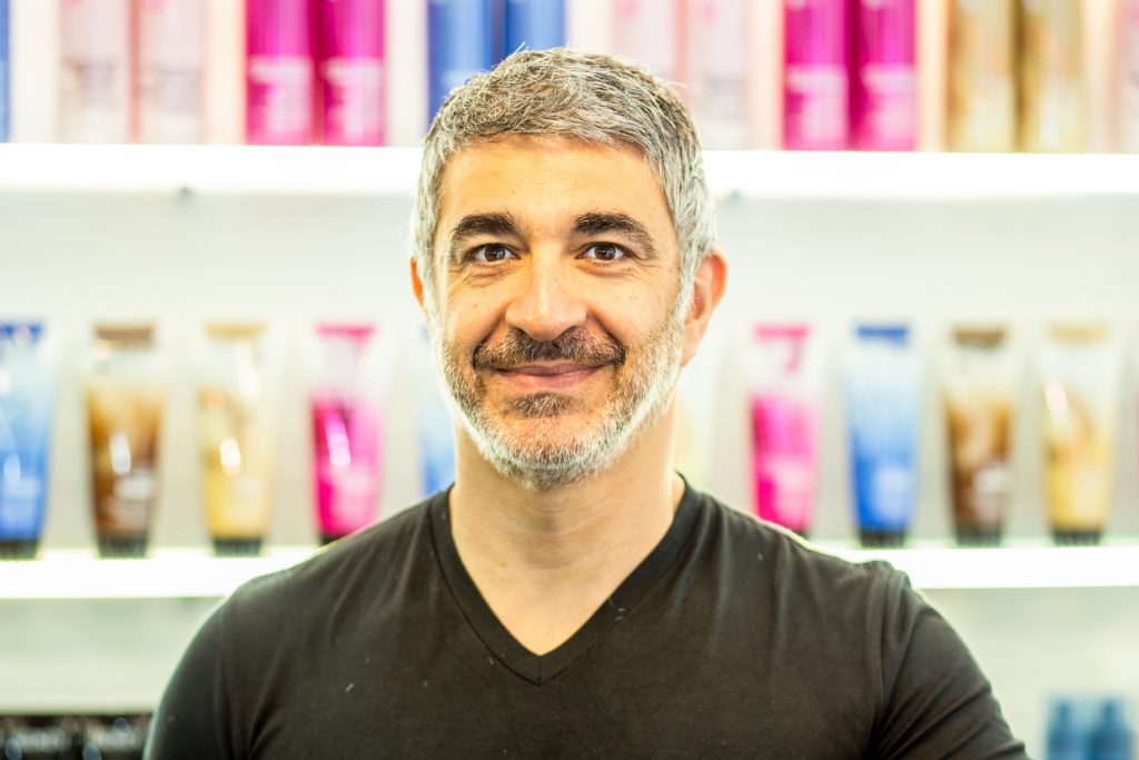 Male hair stylist standing in front of hair products