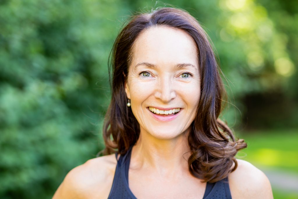 Yoga teacher laughing outside in garden