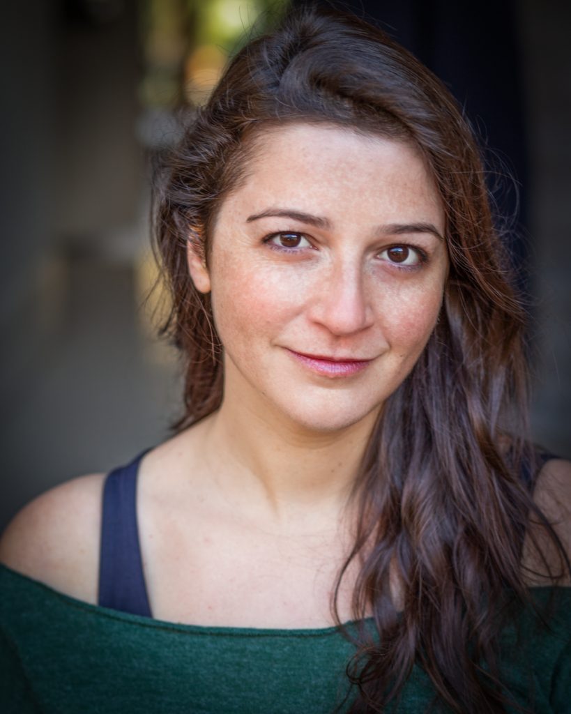 Pretty actress with long dark hair and a green top