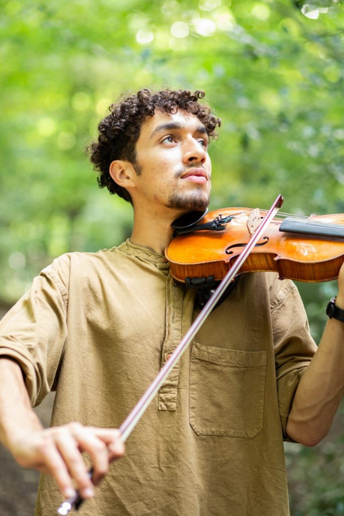Man playing a violin in the woods